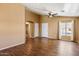 Bright living space featuring wood-look tile floors, a ceiling fan, and a large window at 12621 W Willow Ave, El Mirage, AZ 85335