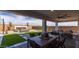 Outdoor dining and living area featuring a fireplace, with turf grass at 12708 W Corona Ave, Avondale, AZ 85323