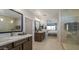 Luxurious bathroom featuring dual sinks with quartz countertops, tiled floors, and a glass-enclosed shower for a spa-like experience at 12708 W Corona Ave, Avondale, AZ 85323