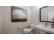 Half bath featuring a pedestal sink and decorative art at 12708 W Corona Ave, Avondale, AZ 85323
