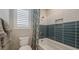 Modern bathroom featuring a shower over tub and stylish blue and white tiling at 12708 W Corona Ave, Avondale, AZ 85323
