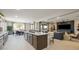 Modern kitchen features a spacious island, stainless steel sink, and seamlessly connects to the dining and living area at 12708 W Corona Ave, Avondale, AZ 85323