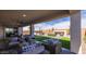 Covered patio featuring outdoor seating and a fireplace, overlooking a paved yard at 12708 W Corona Ave, Avondale, AZ 85323