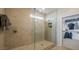 Modern glass shower with tiled walls, built-in shelving, and access to a walk-in closet for added convenience at 12708 W Corona Ave, Avondale, AZ 85323