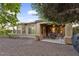 Charming backyard featuring covered patio, desert landscaping, and a gravel ground cover at 12972 W Kokopelli Dr, Peoria, AZ 85383