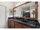 Bathroom with dark countertops, double sinks, a large mirror and a shower at 12972 W Kokopelli Dr, Peoria, AZ 85383