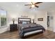 Light-filled main bedroom featuring wood floors, a ceiling fan and a patterned bedspread at 12972 W Kokopelli Dr, Peoria, AZ 85383