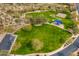 Aerial view of a green park featuring a playground, basketball court, and open space for recreation at 12972 W Kokopelli Dr, Peoria, AZ 85383