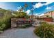 Stone sign for Four Peaks Condominium Homes with plants, blue sky, palm trees, and fountains create an inviting entrance at 13700 N Fountain Hills Blvd # 155, Fountain Hills, AZ 85268
