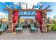 Relaxing poolside lounge area with a pergola, stone columns, and vibrant red curtains on a sunny day at 13700 N Fountain Hills Blvd # 155, Fountain Hills, AZ 85268