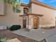 Exterior front entrance with beige stucco, desert landscaping, and a tiled roof at 14000 N 94Th St # 1008, Scottsdale, AZ 85260