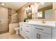 Bright bathroom featuring dual sinks, modern fixtures, white cabinets and a shower with glass doors at 1630 E Minton Dr, Tempe, AZ 85282