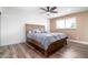 Cozy bedroom featuring wood-look floors, ceiling fan, and a comfortable bed with purple linens at 1630 E Minton Dr, Tempe, AZ 85282