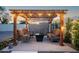 Outdoor seating area under a shaded pergola with mature landscaping and patio lights at 1630 E Minton Dr, Tempe, AZ 85282