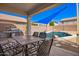 Outdoor patio with a table, chairs, BBQ, and a view of the sparkling pool at 17258 W Meghan Dr, Goodyear, AZ 85338
