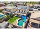 Aerial view of a backyard with a pool, grass, covered patio, and solar panels on the roof at 17258 W Meghan Dr, Goodyear, AZ 85338