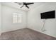 Well-lit bedroom featuring plush carpet, ceiling fan, and modern shutters at 17258 W Meghan Dr, Goodyear, AZ 85338