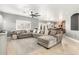 Spacious living room with a large sectional sofa, tile flooring and natural light at 17258 W Meghan Dr, Goodyear, AZ 85338