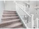 Carpeted stairs with white railing lead to the upper level, blending functionality with a clean aesthetic at 17258 W Meghan Dr, Goodyear, AZ 85338