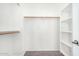 Spacious walk-in closet featuring white shelving units and neutral carpet at 17258 W Meghan Dr, Goodyear, AZ 85338