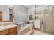 Bright bathroom featuring a soaking tub, tiled shower with glass doors, and neutral finishes at 1739 E Knox Rd, Tempe, AZ 85284