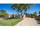 Expansive front lawn and mature trees frame this tan home with tile roof and a circular driveway at 1739 E Knox Rd, Tempe, AZ 85284