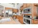 Bright kitchen with stainless steel appliances, oak cabinets, island and adjacent workspace desk at 1739 E Knox Rd, Tempe, AZ 85284