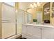 Bright bathroom featuring a double sink vanity with white cabinets, an enclosed shower, and a mirrored backsplash at 174 W Del Rio St, Gilbert, AZ 85233