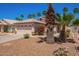 Charming home with a two-car garage, front yard landscaping including grass, bushes, gravel, and palm trees at 174 W Del Rio St, Gilbert, AZ 85233