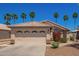 Charming home with a neutral color scheme, a two-car garage, and landscaping including blooming bushes and palm trees at 174 W Del Rio St, Gilbert, AZ 85233