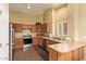 Well-lit kitchen featuring wood cabinets, stainless steel appliances, and tile floors at 174 W Del Rio St, Gilbert, AZ 85233