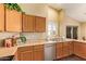 Well-lit kitchen features wood cabinets, stainless steel dishwasher, and sliding glass door at 174 W Del Rio St, Gilbert, AZ 85233