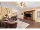 Cozy living room with dark wood floors, ceiling fan, and open layout to dining area at 174 W Del Rio St, Gilbert, AZ 85233