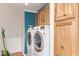 Efficient laundry room featuring modern appliances, ample cabinet space, and stylish blue accent wall at 17913 E Watford Dr, Queen Creek, AZ 85142