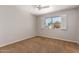 Bright bedroom features a ceiling fan and a window with shutters overlooking the front yard at 1817 W Seldon Ln, Phoenix, AZ 85021