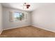 Neutral bedroom with ceiling fan and a window overlooking the neighborhood at 1817 W Seldon Ln, Phoenix, AZ 85021