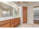 This primary bathroom offers double sinks with wooden cabinetry and a separate closet for added storage at 18562 N Alamo Dr, Surprise, AZ 85374