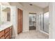 Bright bathroom featuring storage cabinets, tile floors, and glass-enclosed shower at 18562 N Alamo Dr, Surprise, AZ 85374