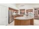 Well-lit kitchen showcasing stainless steel refrigerator, ample counter space and eat-in island at 18562 N Alamo Dr, Surprise, AZ 85374