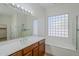 Bathroom featuring dual sinks, wood cabinets, a bathtub, and a glass shower at 18617 E Arrowhead Trl, Queen Creek, AZ 85142