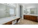 Bathroom featuring dual sinks, wood cabinets, and a large mirror at 18617 E Arrowhead Trl, Queen Creek, AZ 85142
