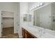 Bathroom featuring a sink, a large mirror, and a doorway leading to the closet and shower at 18617 E Arrowhead Trl, Queen Creek, AZ 85142