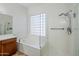Bright bathroom showcasing a soaking tub with glass block window and a separate glass-enclosed shower at 18617 E Arrowhead Trl, Queen Creek, AZ 85142