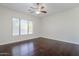 Sun-filled bedroom with window, fan and gleaming wood floors at 18617 E Arrowhead Trl, Queen Creek, AZ 85142