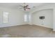 Comfortable living room boasts a ceiling fan, large windows, and neutral paint at 18617 E Arrowhead Trl, Queen Creek, AZ 85142