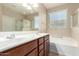 Well-lit bathroom with a double vanity, soaking tub, and a separate glass-enclosed shower area at 18896 N Lariat Rd, Maricopa, AZ 85138