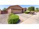 Single-story home featuring desert landscaping, a two-car garage, and an extended driveway at 18896 N Lariat Rd, Maricopa, AZ 85138