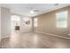 Bright and airy living room with wood-look floors and an open view to the kitchen at 18896 N Lariat Rd, Maricopa, AZ 85138
