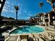 Resort-style pool with lounge chairs, palm trees, and clear blue water at 2025 E Campbell Ave # 132, Phoenix, AZ 85016