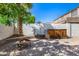 Brick backyard with an inviting fire pit, wood storage, and a privacy wall, perfect for outdoor gatherings at 2028 S Esmeralda --, Mesa, AZ 85209